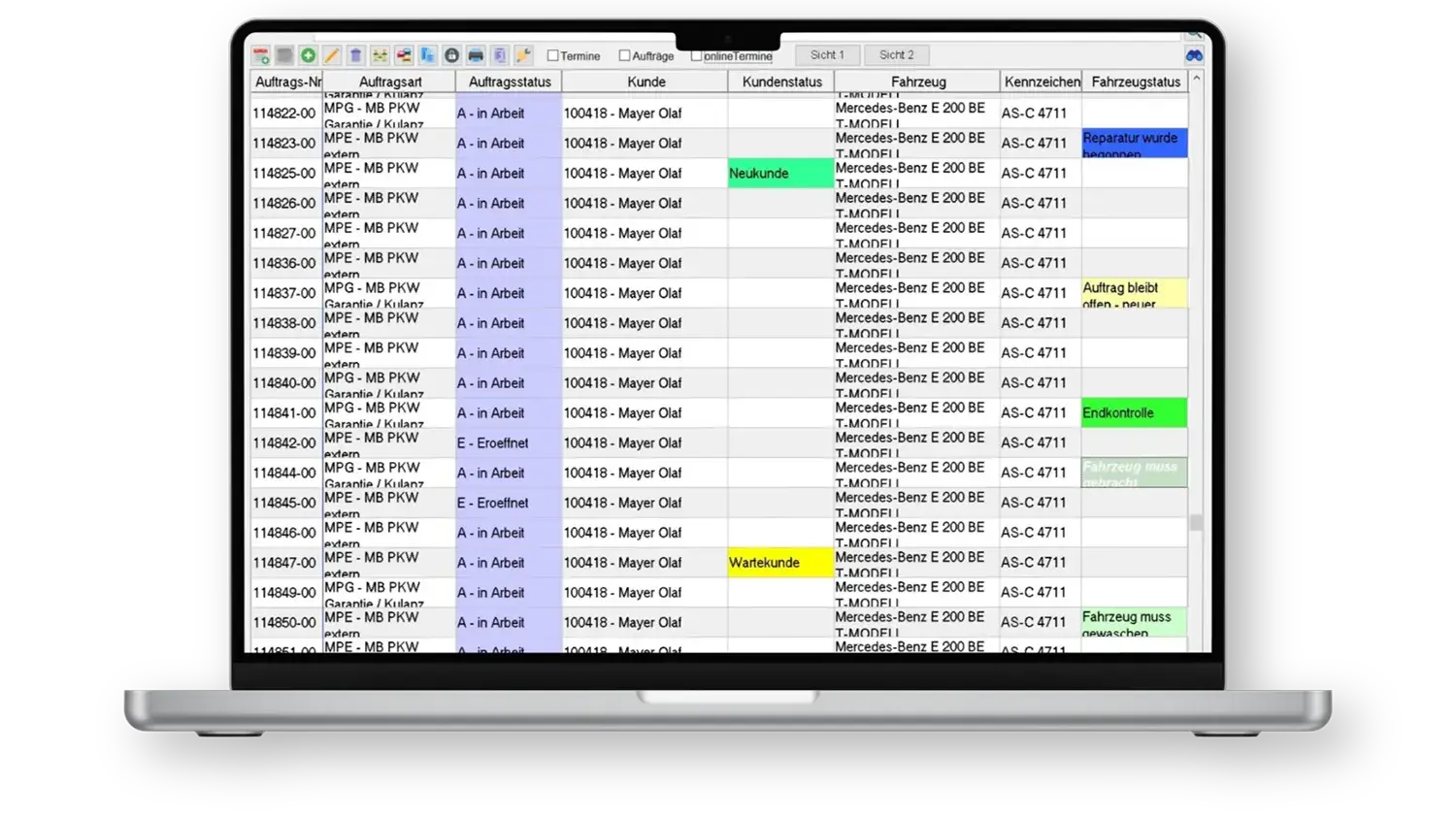 Laptopbildschirm mit Tabellenansicht von Auftragsdaten, farblich markierte Statusfelder in Gelb, Grün und Blau